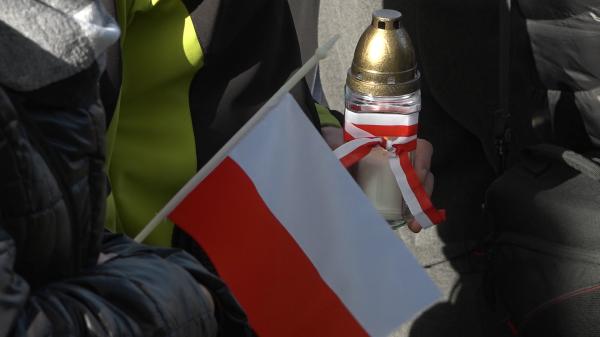 Znicz owinięty w biało-czerwone kolory i flaga - kliknij aby powiększyć
