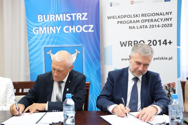 Rewitalizacja Placu 1 Maja w Choczu to projekt realizowany przy wsparciu marszałkowskich środków unijnych w ramach Wielkopolskiego Regionalnego Programu Operacyjnego na lata 2014-2020. 23 maja 2022 roku w Urzędzie Miejskim Gminy Chocz Marek Woźniak Marszałek Województwa Wielkopolskiego podpisał z Burmistrzem Marianem Wielgosikiem umowę ws. dofinansowania wartego 4 mln zł przedsięwzięcia kwotą 2 327 mln zł.  - kliknij aby powiększyć