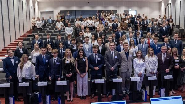 Zdjęcie grupowe radnych Młodzieżowego Sejmiku oraz zaproszonych gości, pozujących wspólnie w sali sesyjnej.- kliknij aby powiększyć