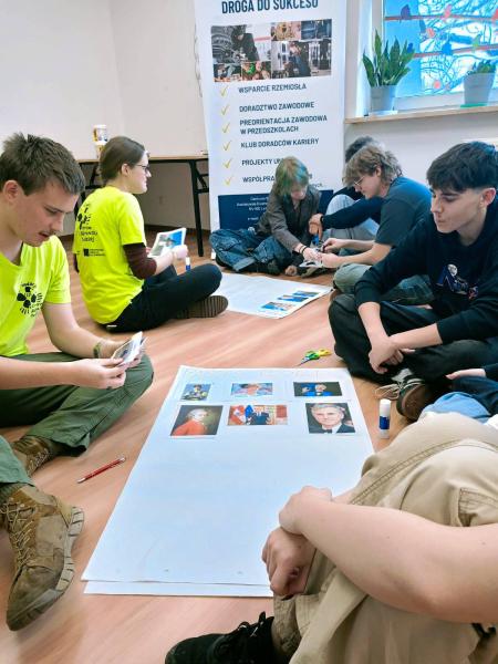 Na zdjęciu uczniowie podczas warsztatów międzykulturowych w Fundacji Centrum Aktywności Twórczej. Młodzież siedzi na ziemi i wykonuje zadanie w grupach, polegające na stworzeniu plakatu z obyczajami danego państwa.- kliknij aby powiększyć