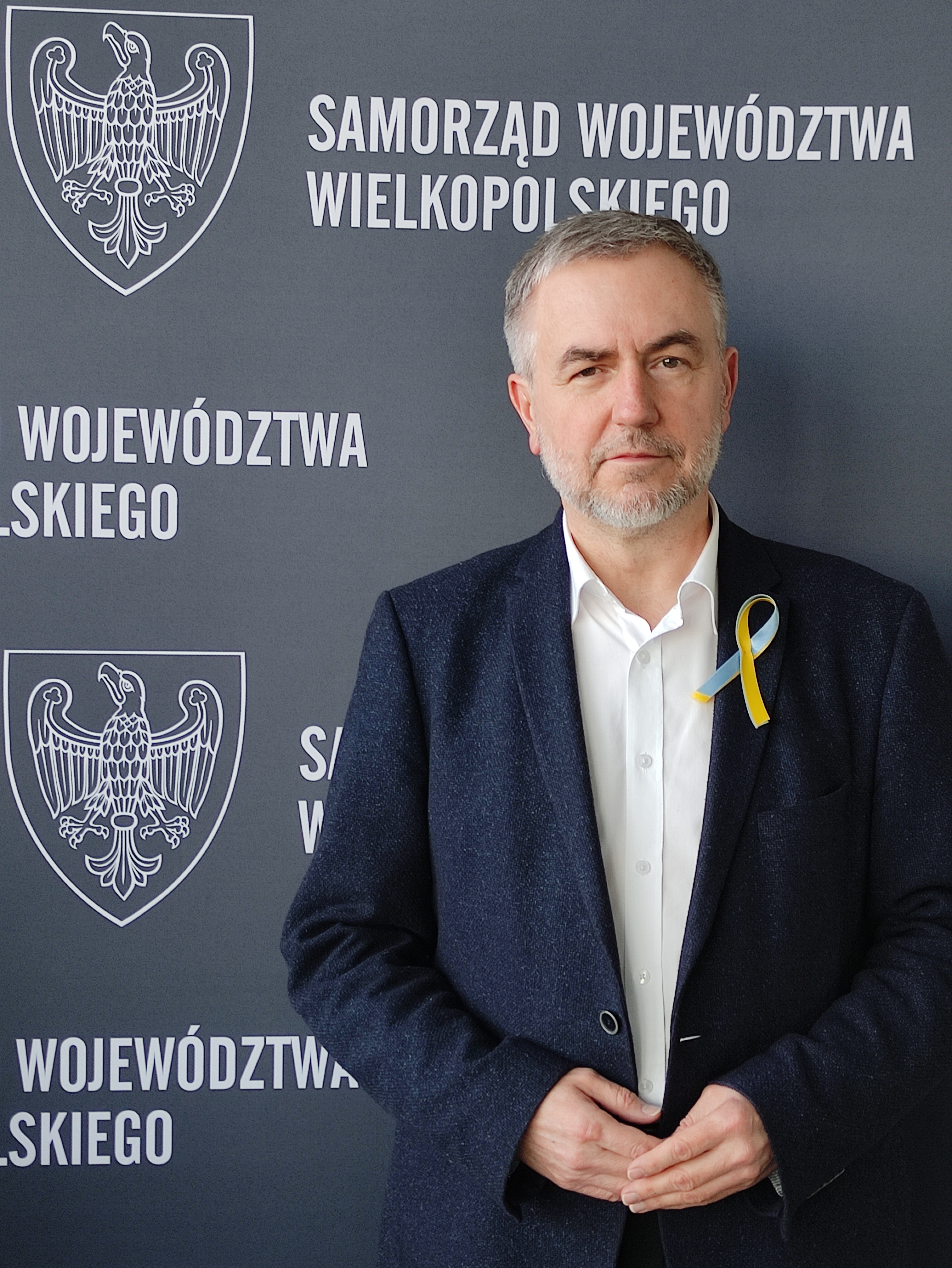 Marszałek Marek Wożniak ze wstążką w barwach flagi Ukrainy
